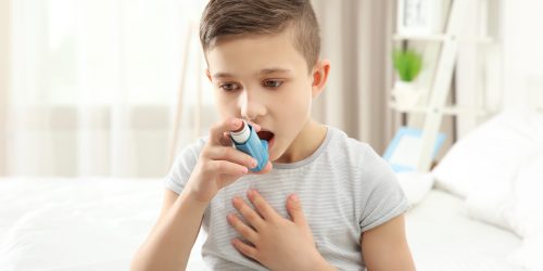 Child experiencing breathing difficulty using an Albuterol inhaler for quick relief, illustrating proper Albuterol Dosage and administration.